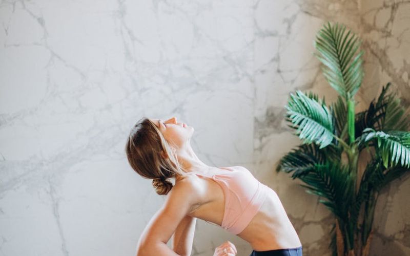 Person performing a flowing yoga sequence in a bright studio.